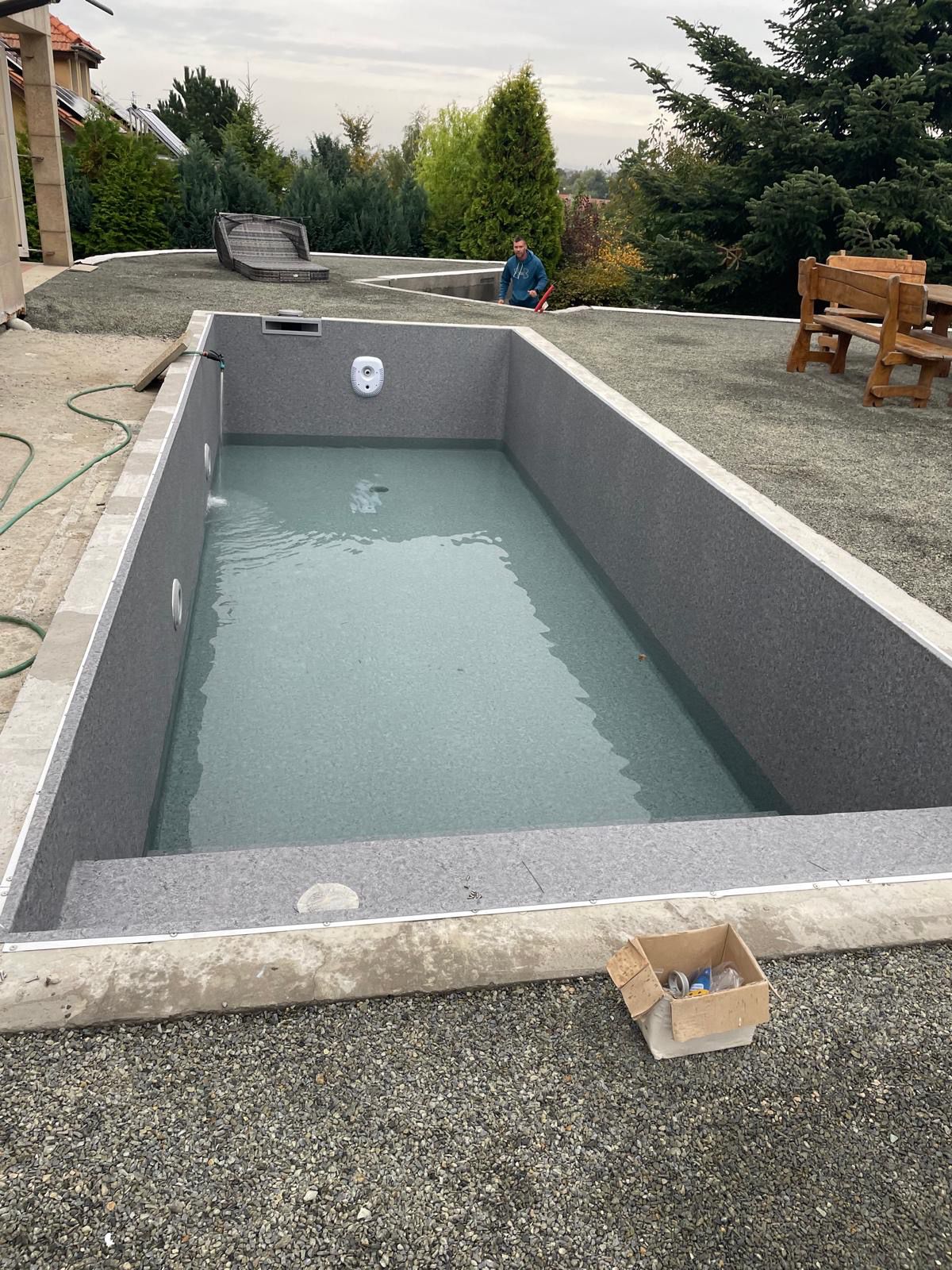 Dokončený bazén se šedou fólií a napuštěnou vodou